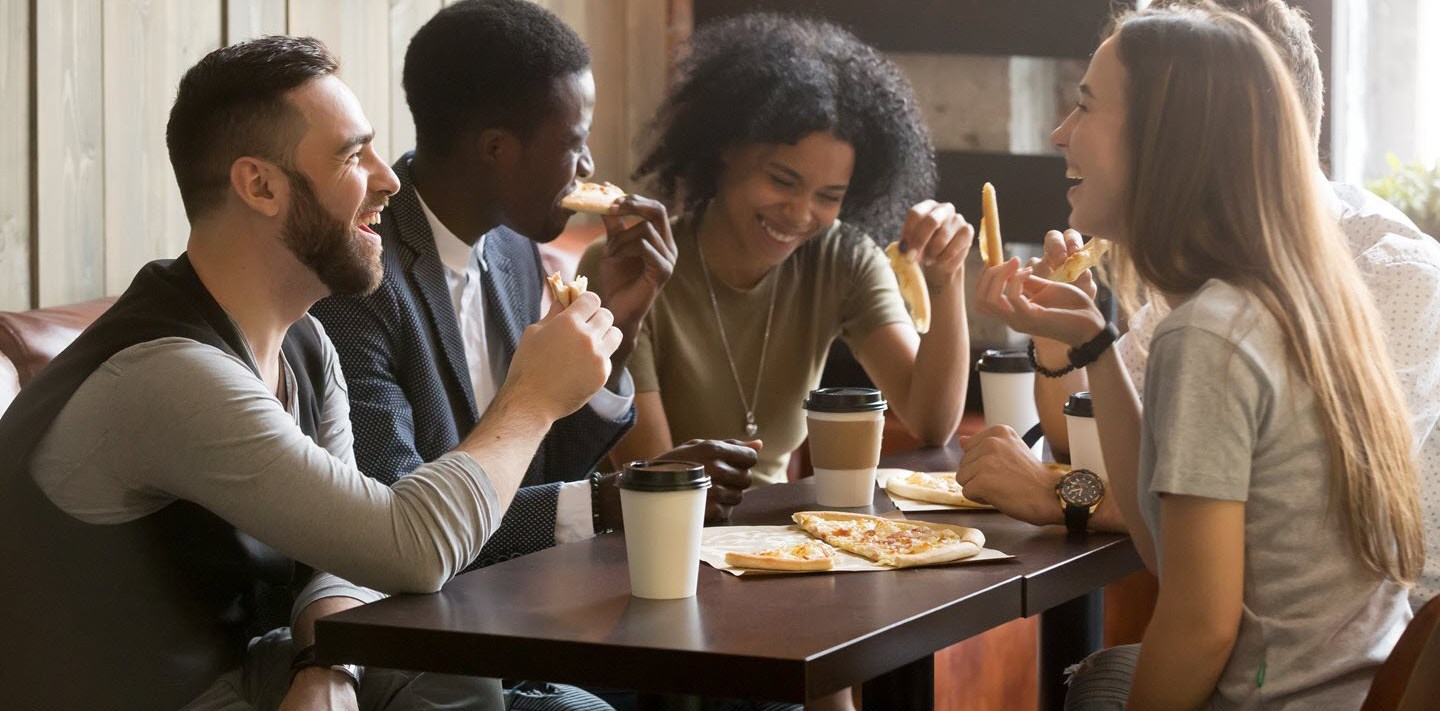 Friend eating pizza and smiling