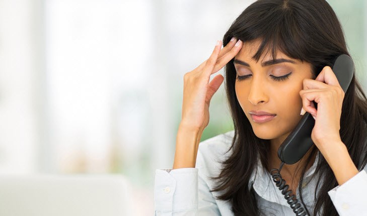 Girl talking on a phone and holding her head
