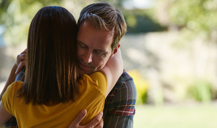 Man and woman hugging at the park