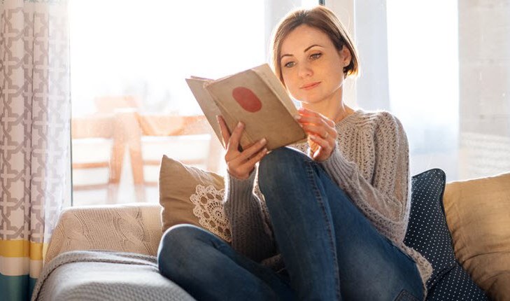 Woman reading a book on the sofa