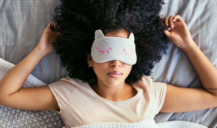 Woman sleeping in the bed with sleeping mask