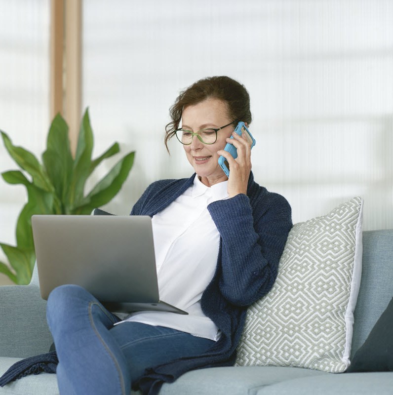 Busy woman working on a laptop and talking on the phone